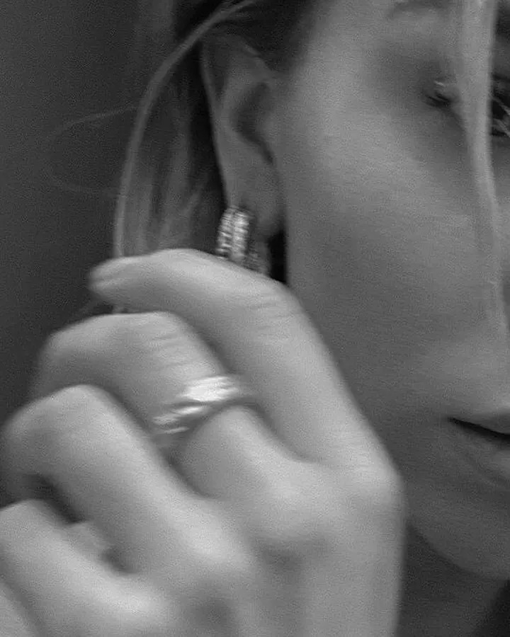 Femme en haut noir transparent, prenant un selfie devant un miroir dans une salle de bain.