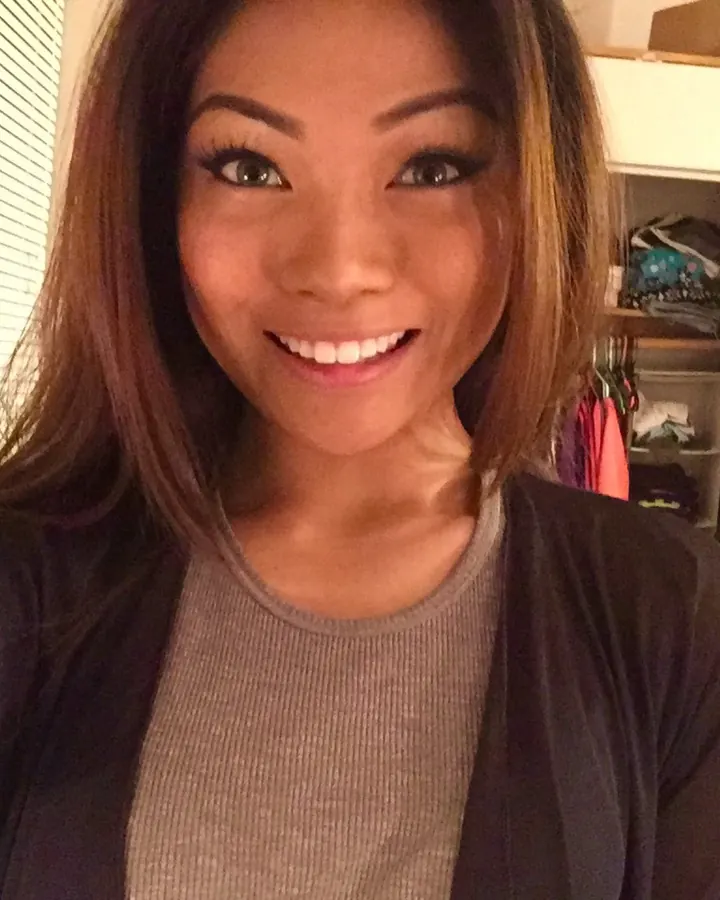 Femme aux cheveux bruns en haut violet posant pour un selfie
