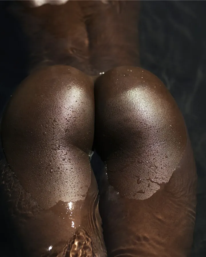 Plan rapproché des fesses d'une femme aux cheveux foncés, dans l'eau.