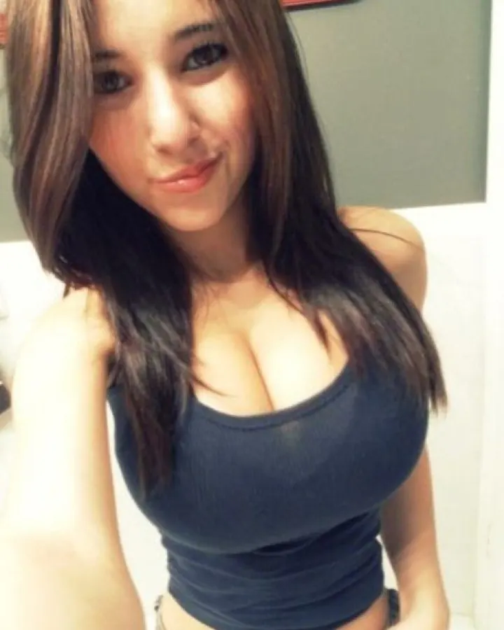 Femme aux cheveux châtains portant un haut bleu foncé, souriant à la caméra.