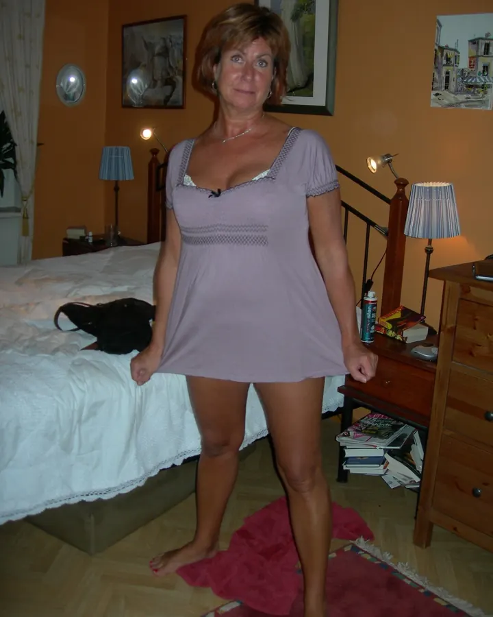 Femme mûre en nuisette lilas dans une chambre