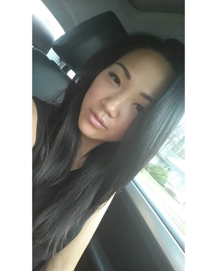 Femme asiatique nue du buste, portant un collier, mains sur les hanches, regardant directement l'objectif.