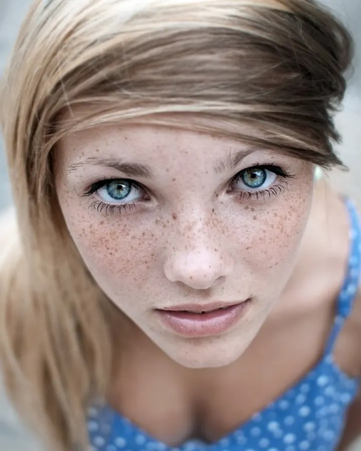 Femme aux cheveux châtains, portant un haut noir et un short en jean, prenant un selfie dans un dressing.