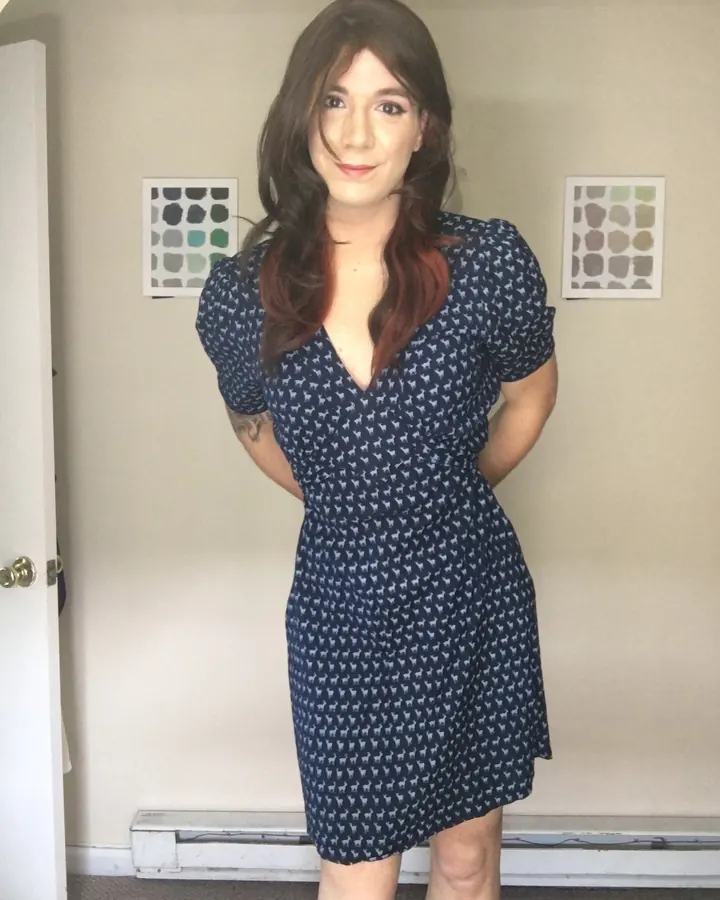 Femme aux cheveux châtains, portant un haut noir et un short en jean, prenant un selfie dans un dressing.