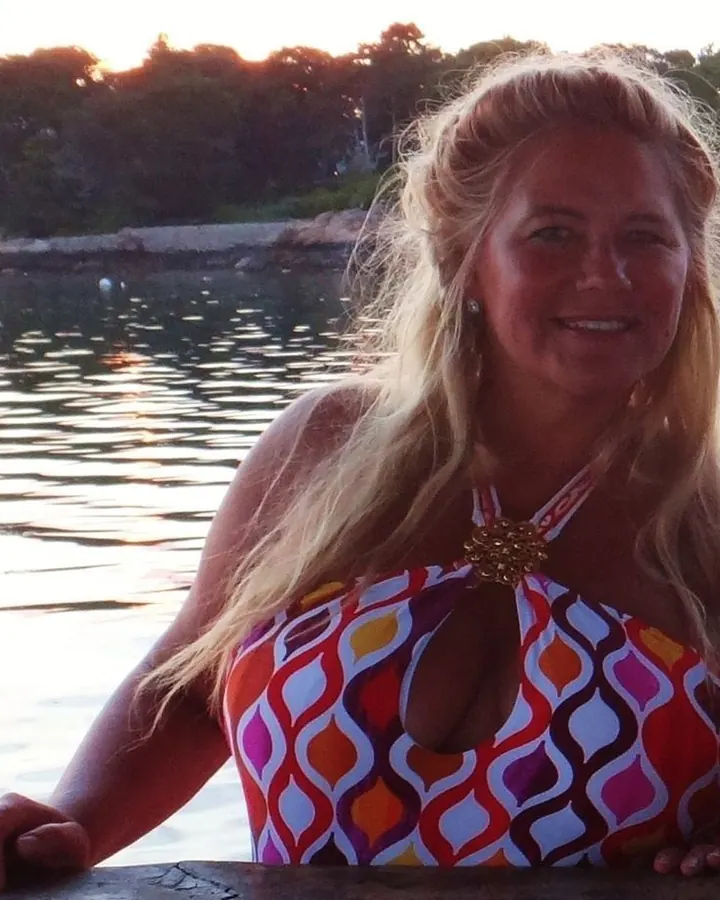 Femme blonde en maillot coloré au bord de l’eau